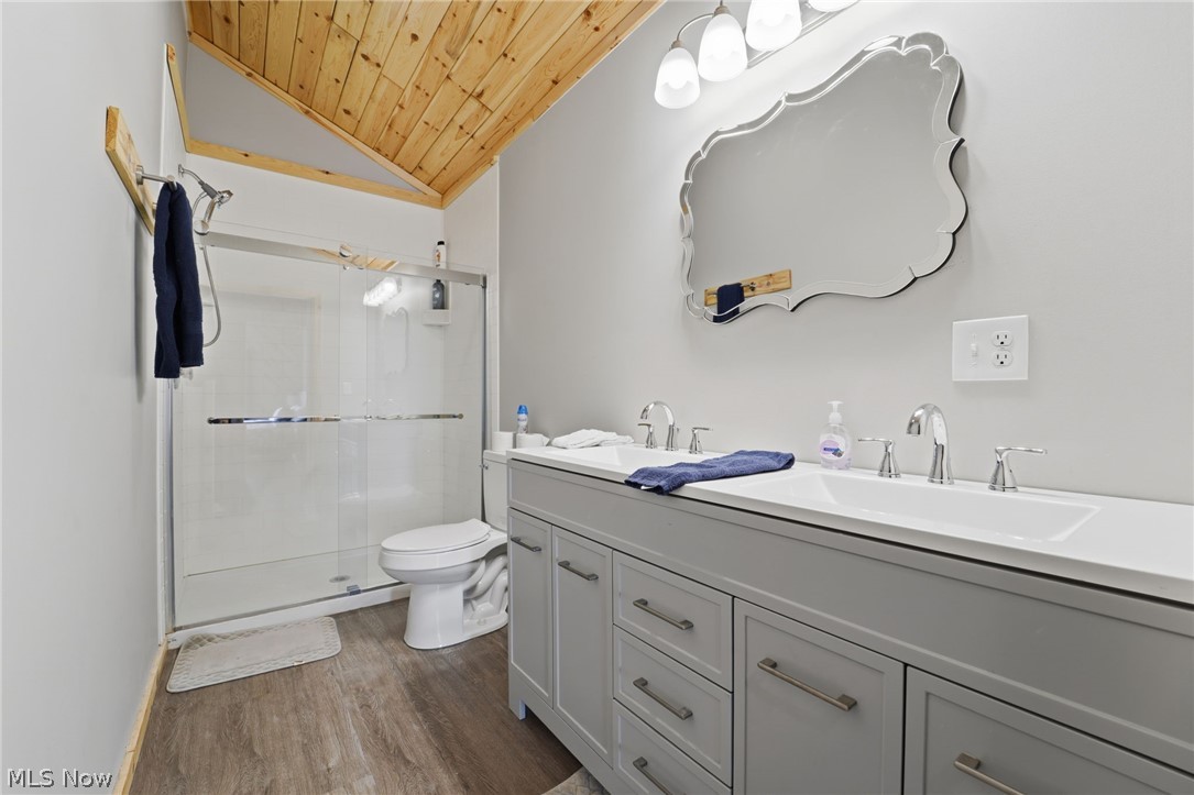 5919 Lake Road West, Unit 33 Ashtabula, OH 44004 - Photo 20 of 22 Full bathroom with double vanity, a stall shower, a vaulted wooden ceiling, and dark wood-type flooring