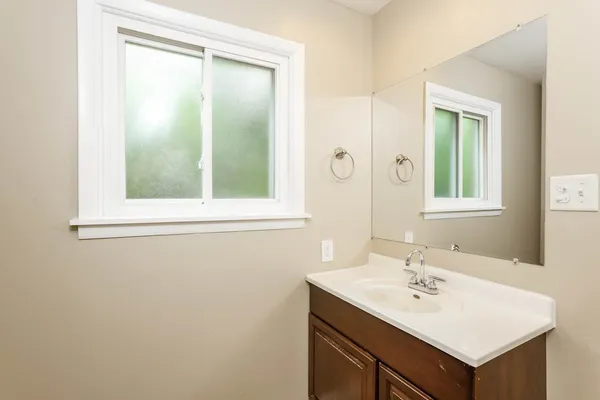 a bathroom with a sink a mirror and a window