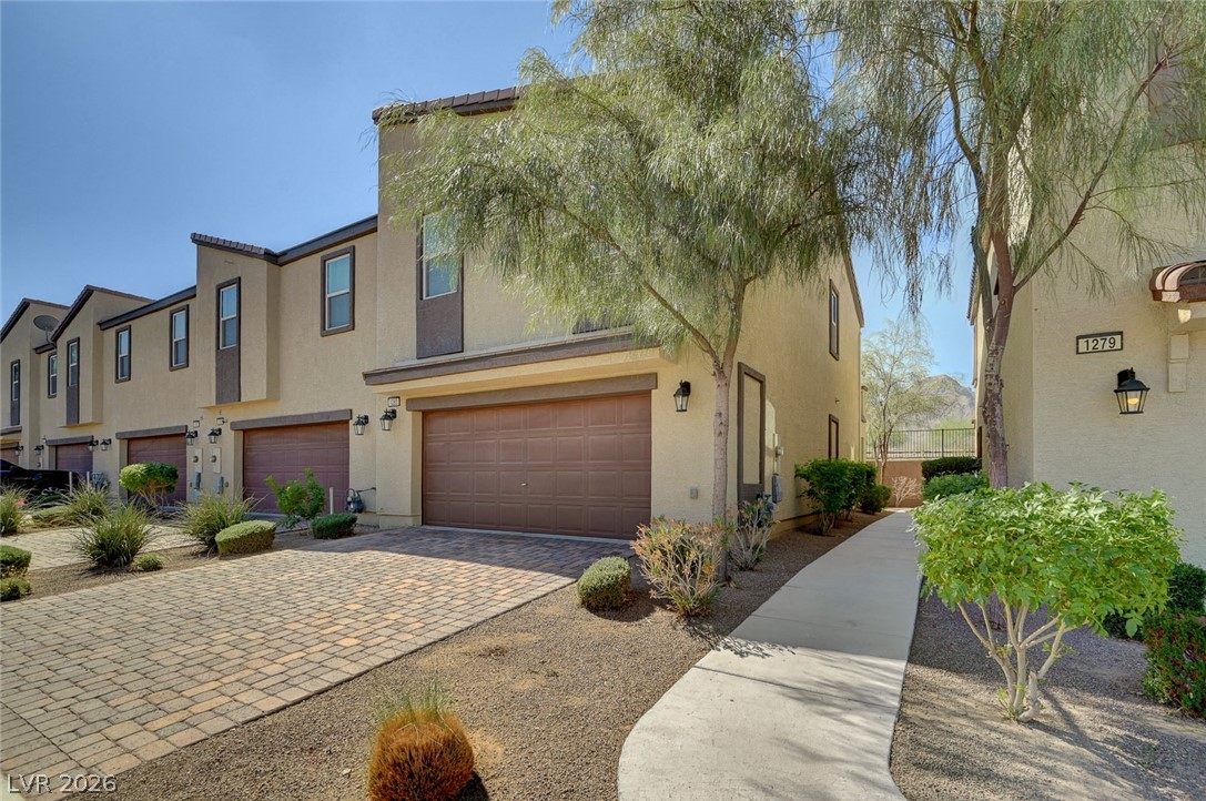1285 Raritan Place Henderson, NV 89002 - Photo 19 of 20 Paved driveways and desert landscaping frame this modern multi-level townhouse exterior.