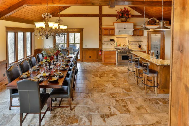 a dining room filled with lots of furniture and a chandelier