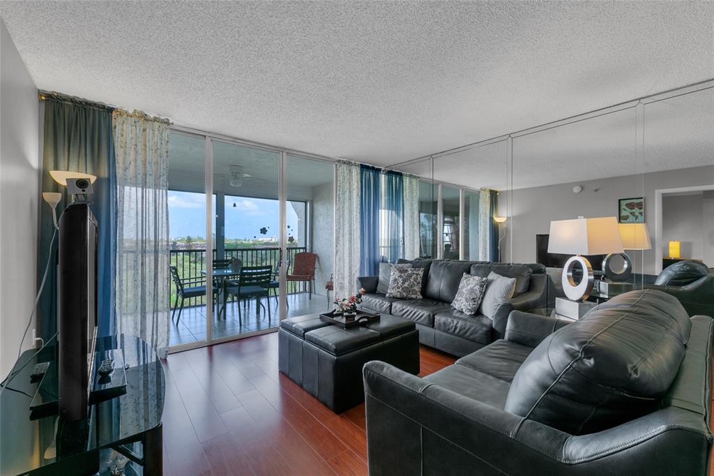 3940 Inverrary Boulevard, Unit 806A Fort Lauderdale, FL 33319 - Photo 15 of 36 a living room with furniture a wooden floor and a large window