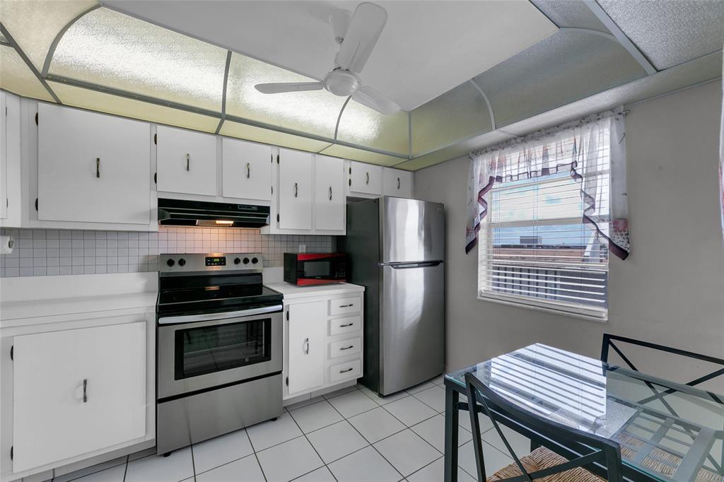 3940 Inverrary Boulevard, Unit 806A Fort Lauderdale, FL 33319 - Photo 24 of 36 a kitchen with stainless steel appliances and chandelier