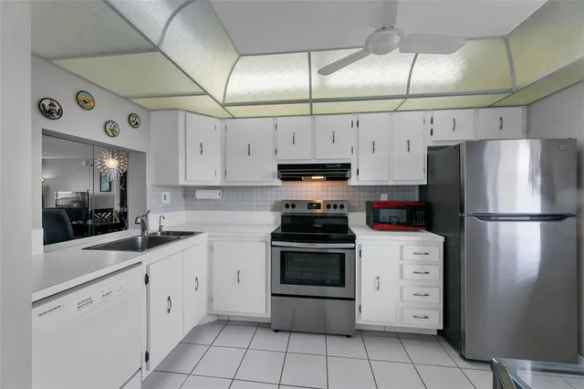 a kitchen with cabinets stainless steel appliances and a counter space