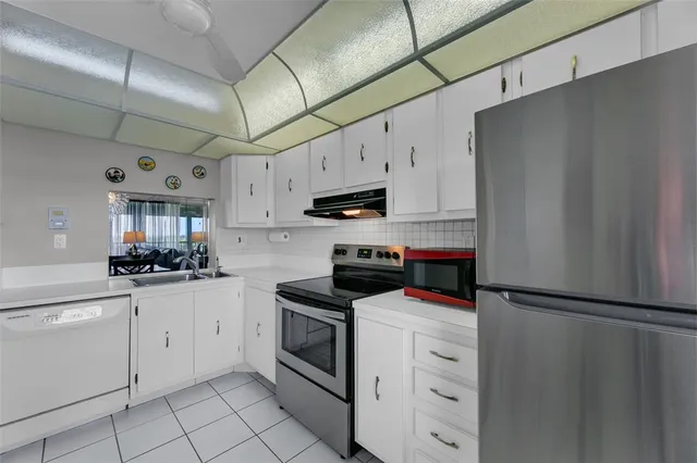 a kitchen with white cabinets and white appliances