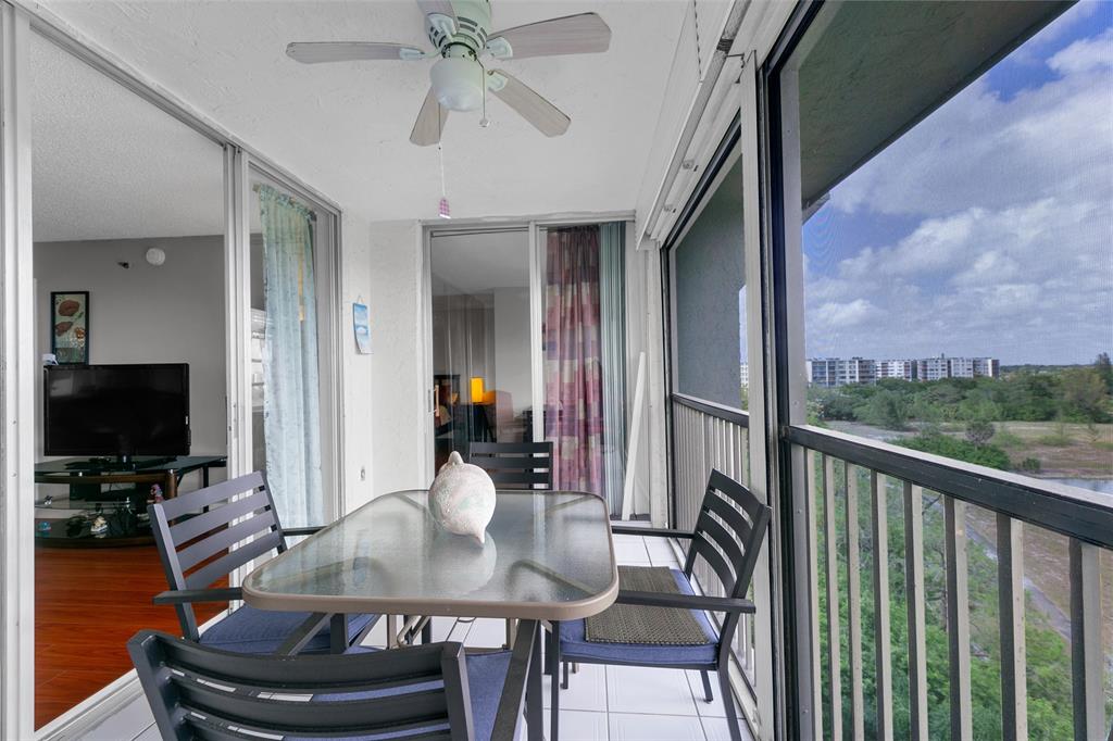 3940 Inverrary Boulevard, Unit 806A Fort Lauderdale, FL 33319 - Photo 4 of 36 a dining room with wooden floor and a floor to ceiling window