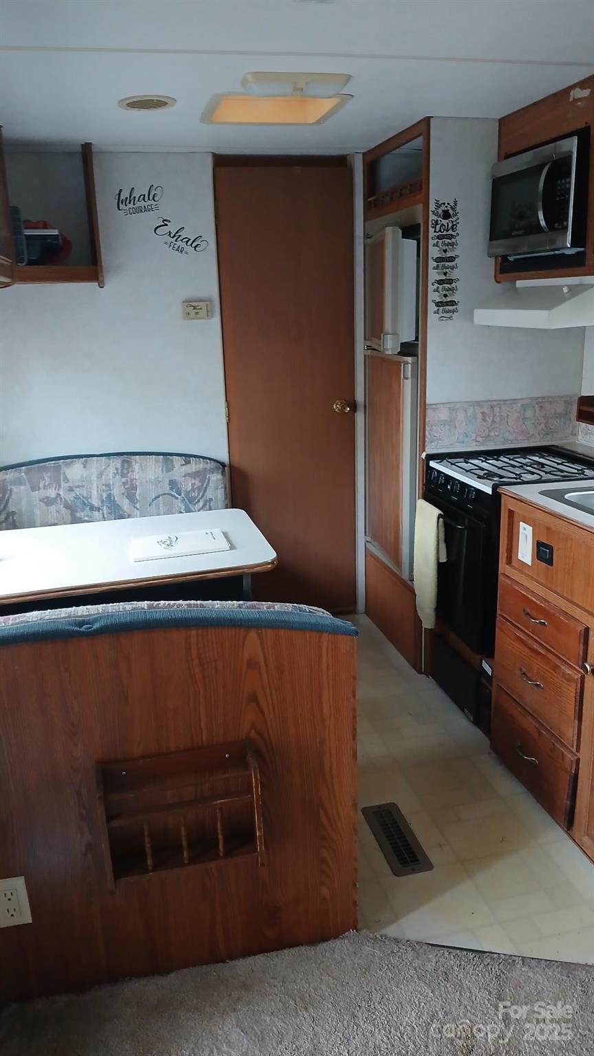2830 Burgin Smith Road Vale, NC 28168 - Photo 35 of 38 a kitchen with stainless steel appliances granite countertop a stove a microwave and a refrigerator