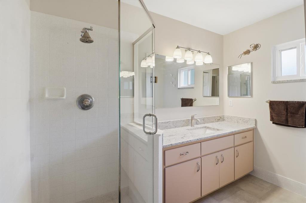 11263 Southwest 138th Lane Dunnellon, FL 34432 - Photo 15 of 53 a bathroom with a granite countertop sink a mirror and a shower