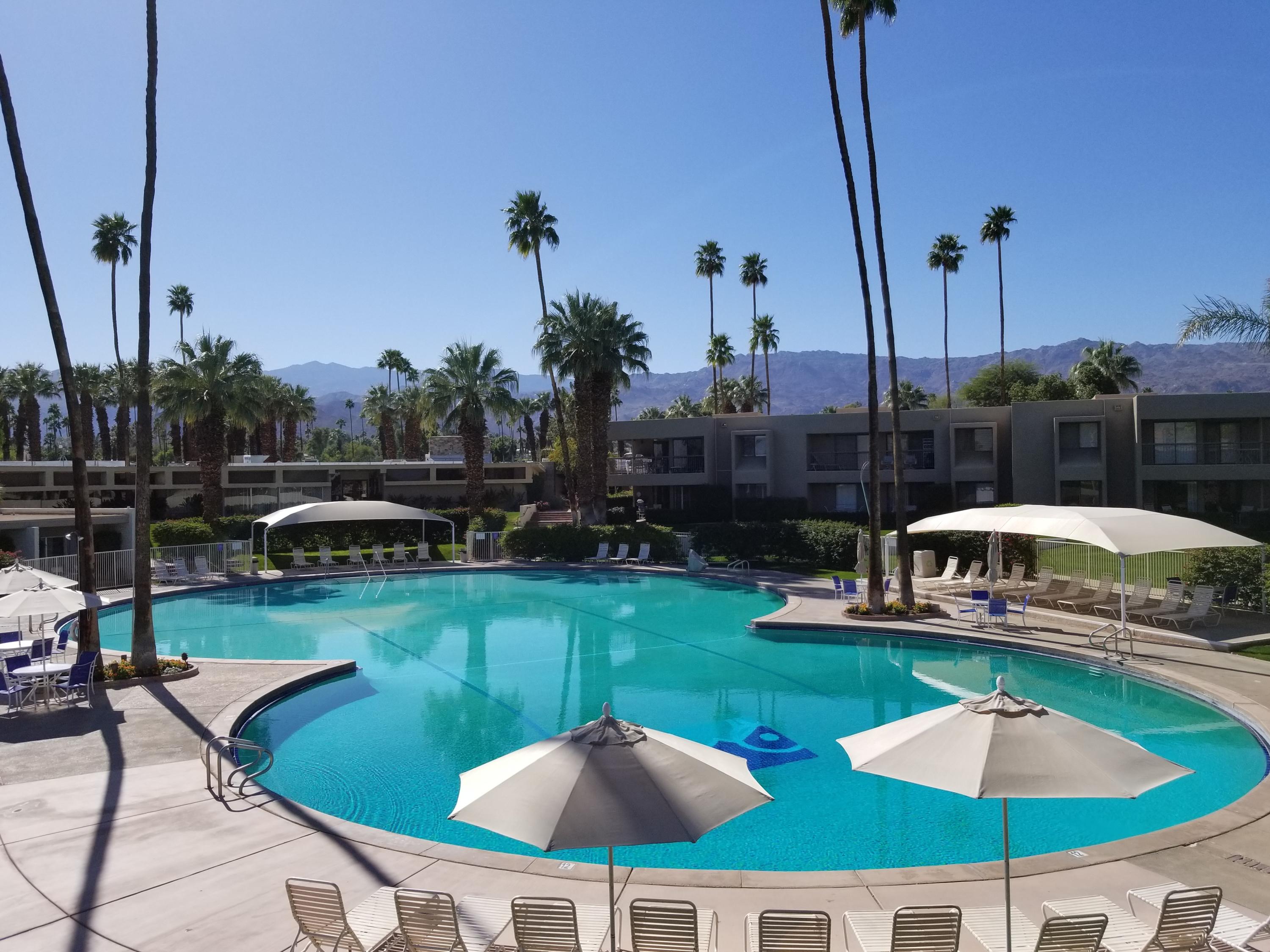 45735 Juniper Circle, Unit 522 Palm Desert, CA 92260 - Photo 46 of 53 a view of a swimming pool with a garden and patio