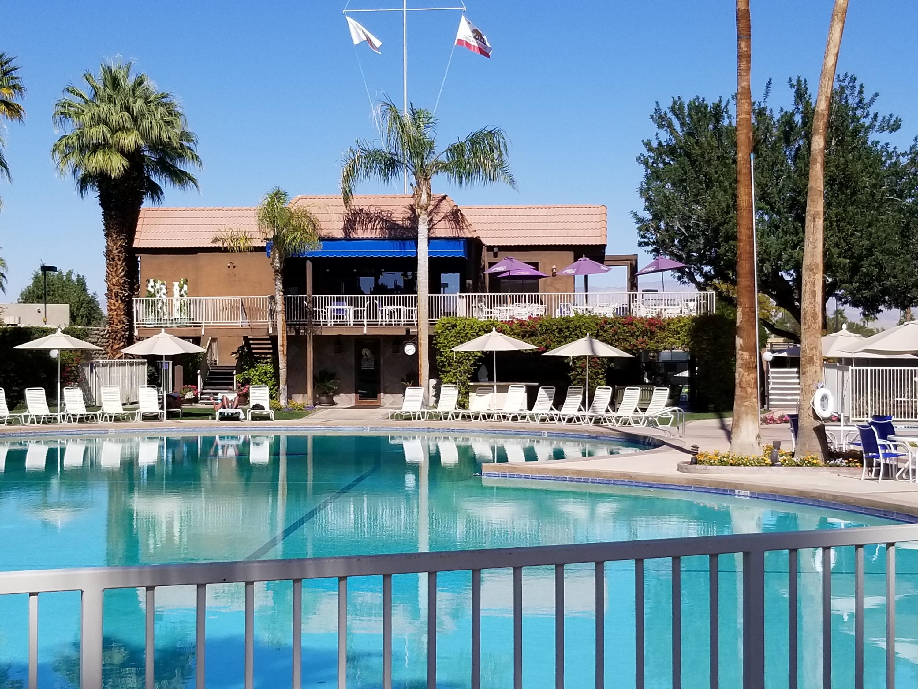 45735 Juniper Circle, Unit 522 Palm Desert, CA 92260 - Photo 47 of 53 a view of a swimming pool with a house in the background