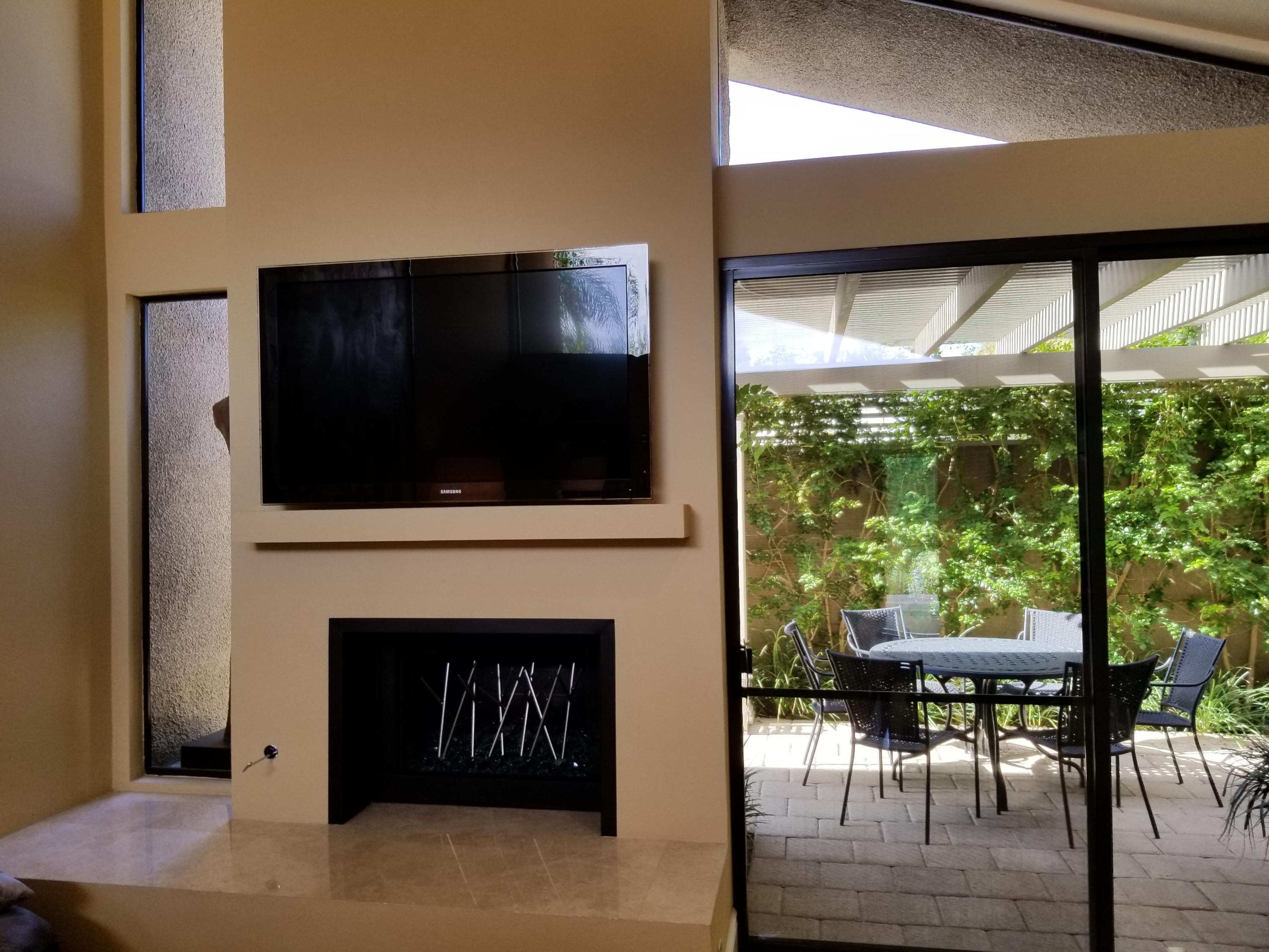 45735 Juniper Circle, Unit 522 Palm Desert, CA 92260 - Photo 6 of 53 a living room with a fireplace and a flat screen tv