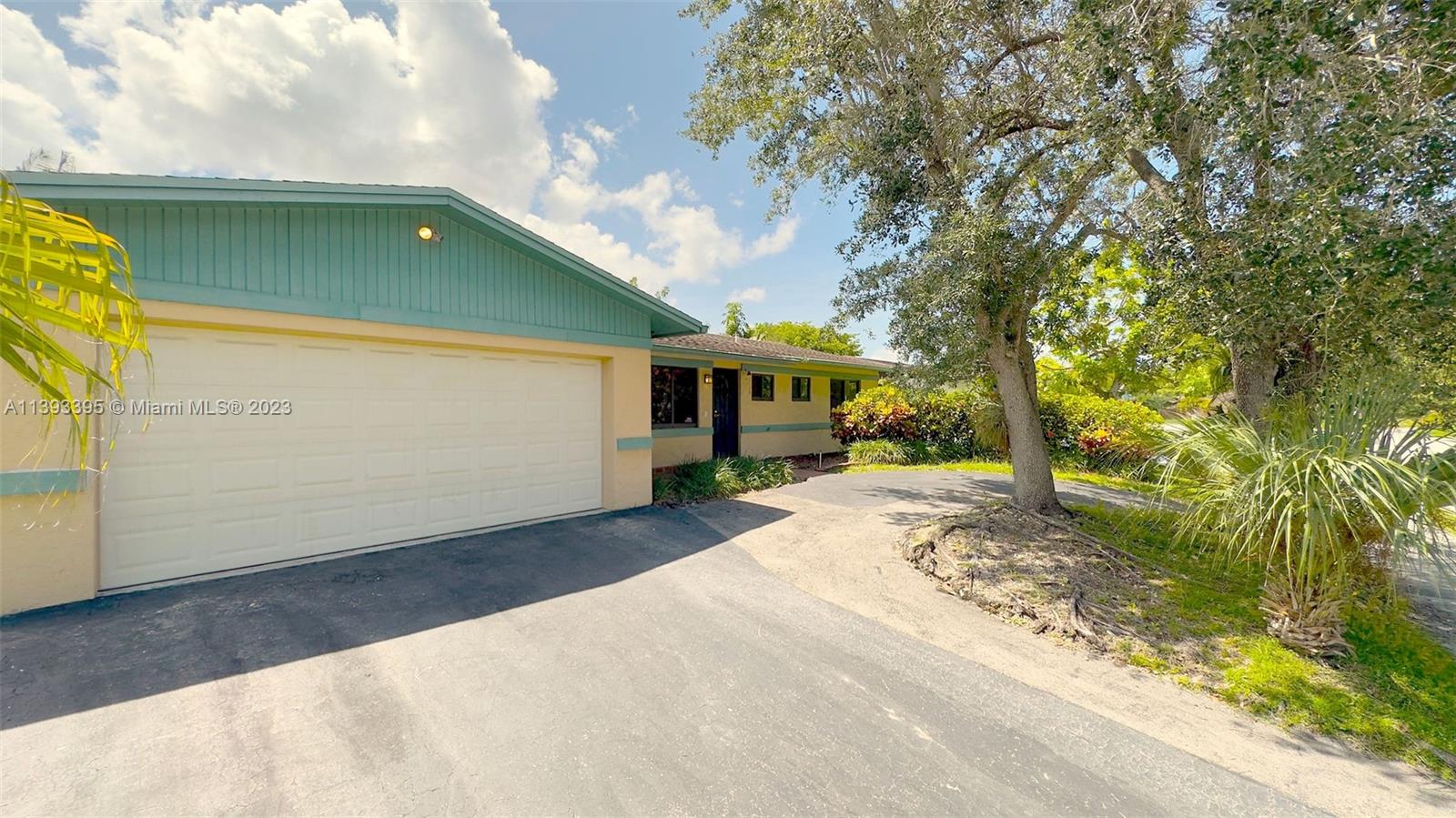 11412 Southwest 113th Place Miami, FL 33176 - Photo 3 of 16 a view of a house with a backyard and a garage