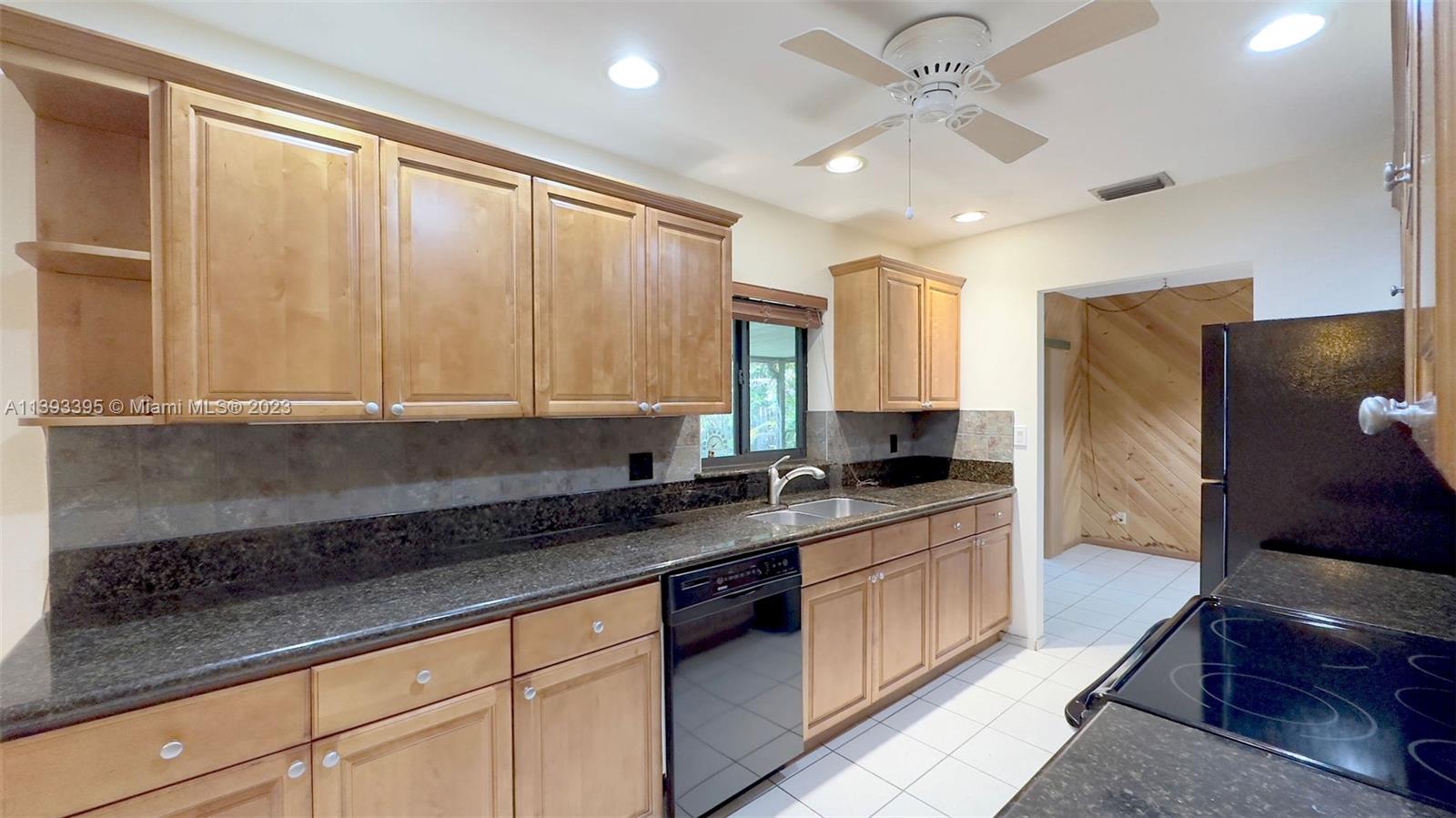 11412 Southwest 113th Place Miami, FL 33176 - Photo 8 of 16 a kitchen with stainless steel appliances granite countertop a sink a stove and a refrigerator