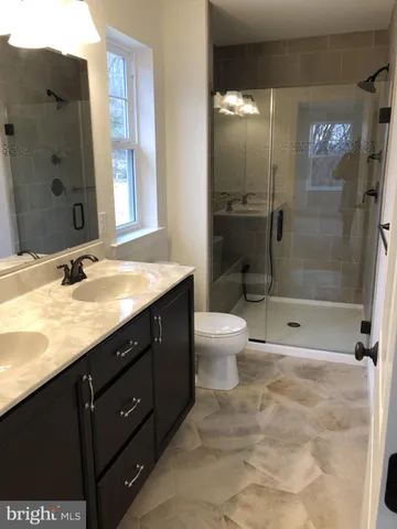 a bathroom with a granite countertop sink toilet and shower