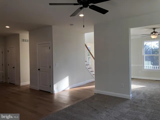 an empty room with wooden floor cabinet and windows