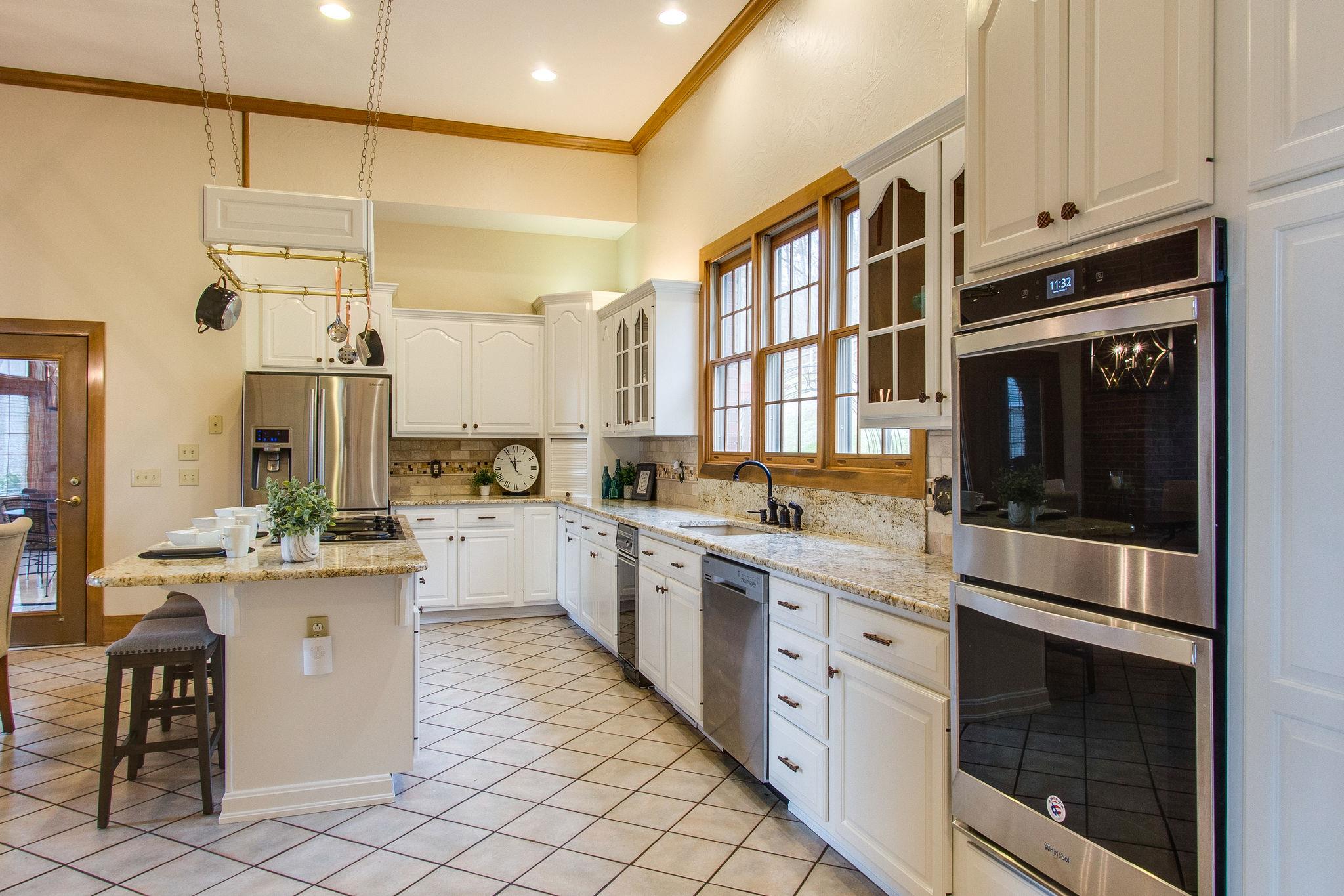 1026 Holly Tree Gap Road Brentwood, TN 37027 - Photo 10 of 27 a kitchen with stainless steel appliances kitchen island granite countertop a stove and cabinets