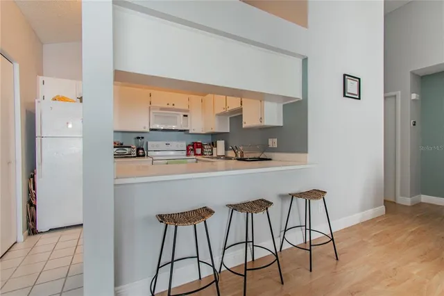 a kitchen with stainless steel appliances kitchen island granite countertop furniture and a refrigerator