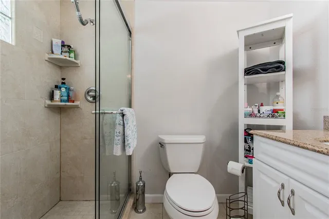a white toilet sitting next to a bathroom sink and vanity