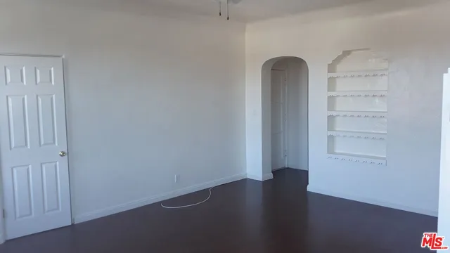 an empty room with wooden floor and closet