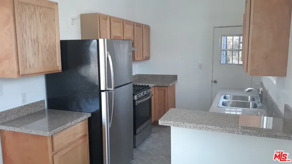 a kitchen with granite countertop a refrigerator and a sink