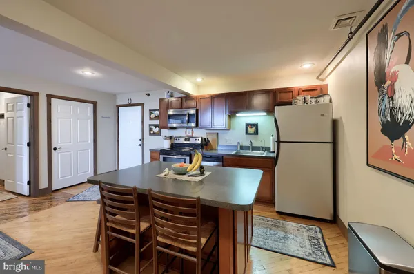 a kitchen with a table chairs refrigerator and wooden cabinets