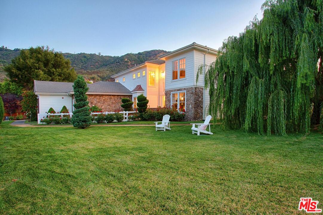 423 Woodbluff Road Monte Nido, CA 91302 - Photo 2 of 31 a front view of a house with a garden