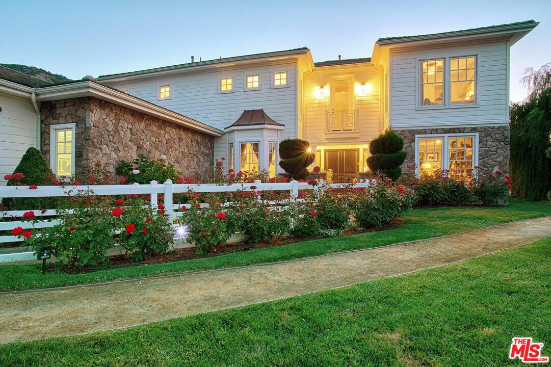 423 Woodbluff Road Monte Nido, CA 91302 - Photo 3 of 31 a front view of house and yard with beautiful flowers and green space