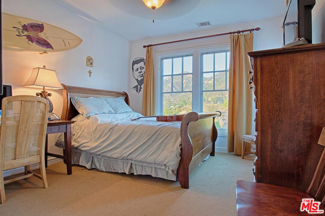 423 Woodbluff Road Monte Nido, CA 91302 - Photo 23 of 31 a bedroom with a bed chair and a window