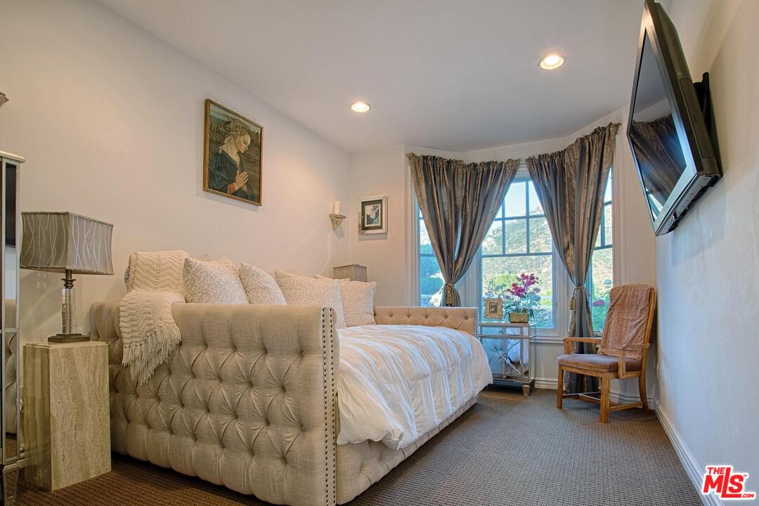 423 Woodbluff Road Monte Nido, CA 91302 - Photo 24 of 31 a bedroom with a bed couch and window