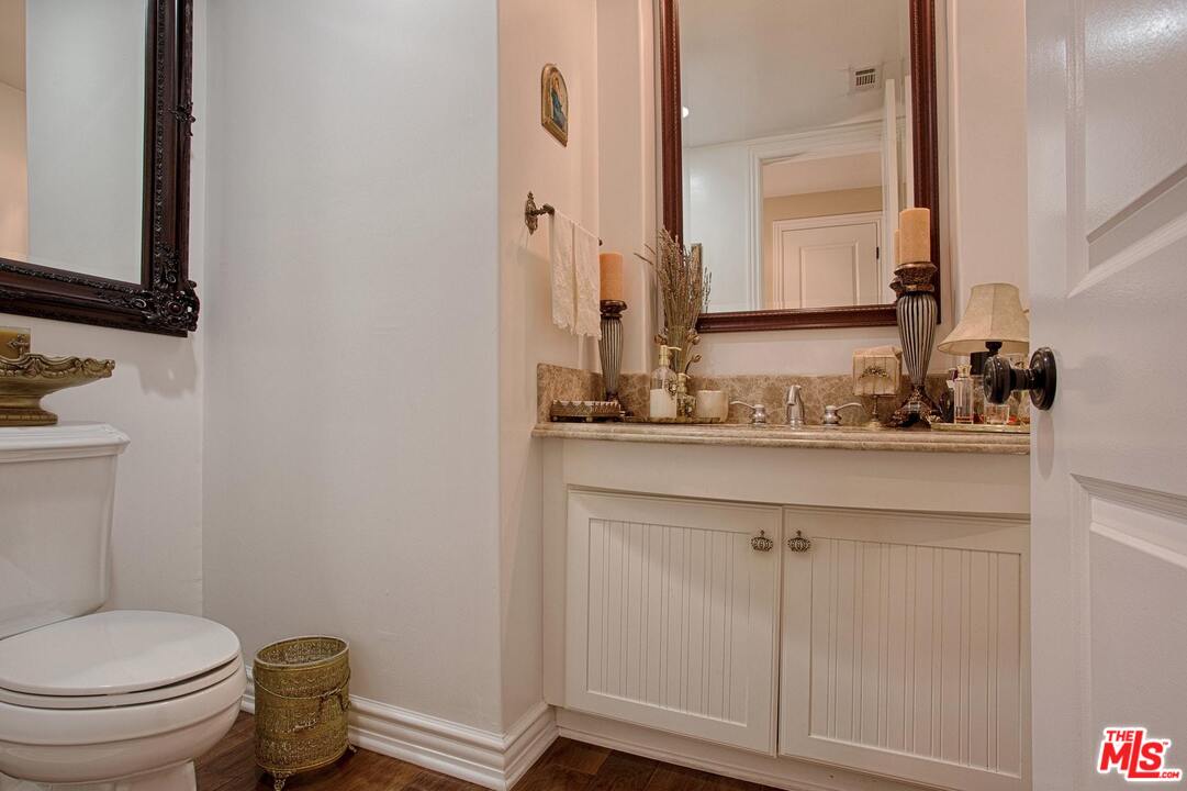 423 Woodbluff Road Monte Nido, CA 91302 - Photo 25 of 31 a bathroom with a granite countertop toilet sink and mirror