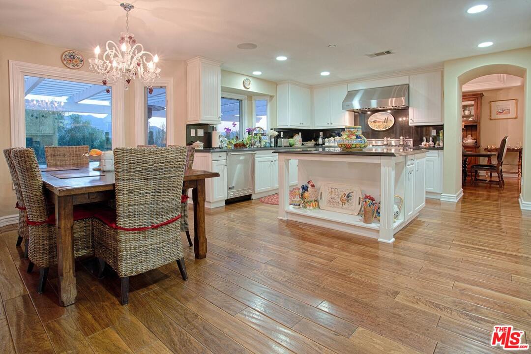 423 Woodbluff Road Monte Nido, CA 91302 - Photo 8 of 31 a living room with kitchen island furniture and a chandelier