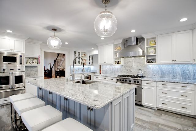 a large kitchen with granite countertop a stove oven and a sink with granite countertops