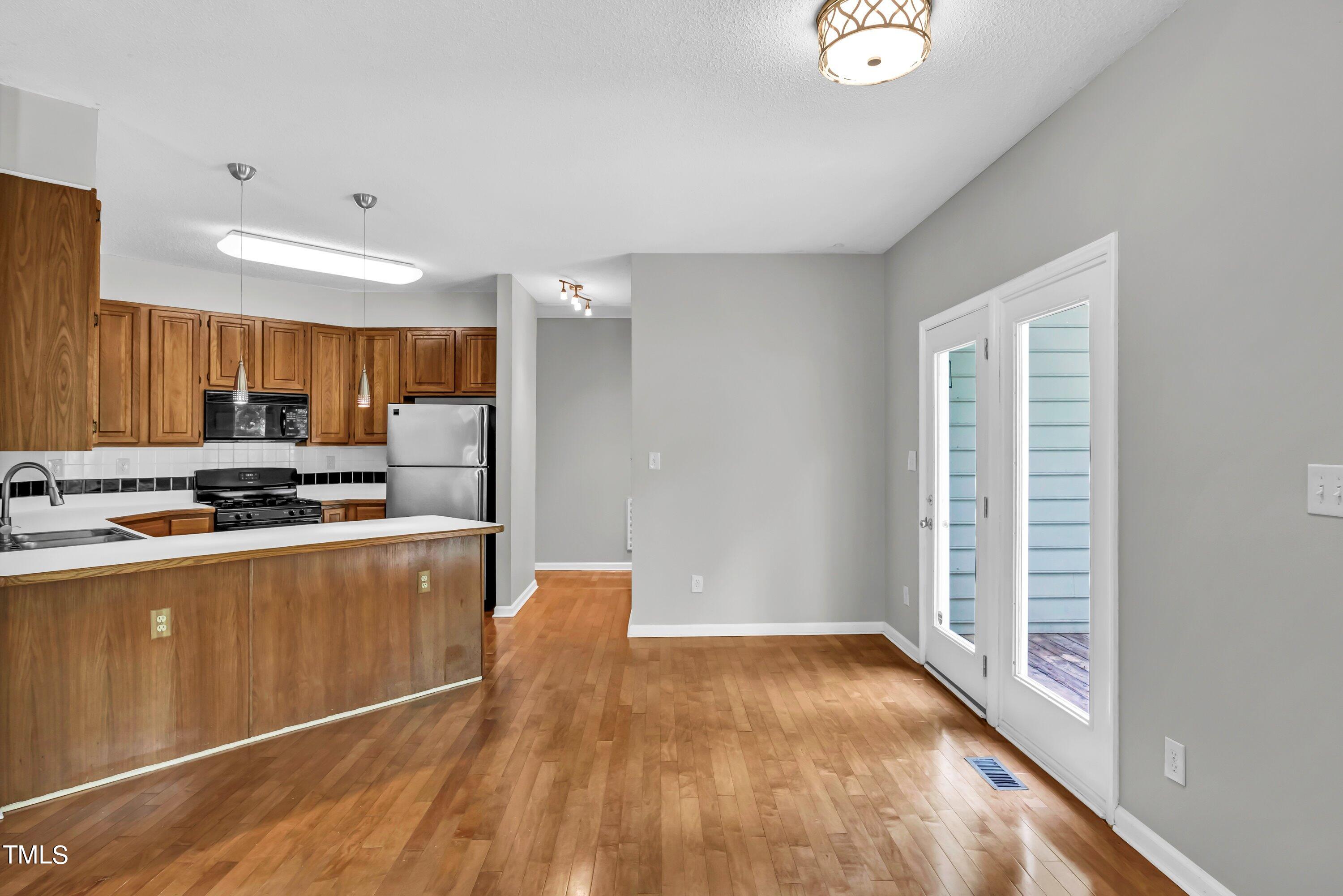 816 Kings Cross Way Raleigh, NC 27615 - Photo 7 of 41 a view of kitchen with stainless steel appliances wooden floor and window