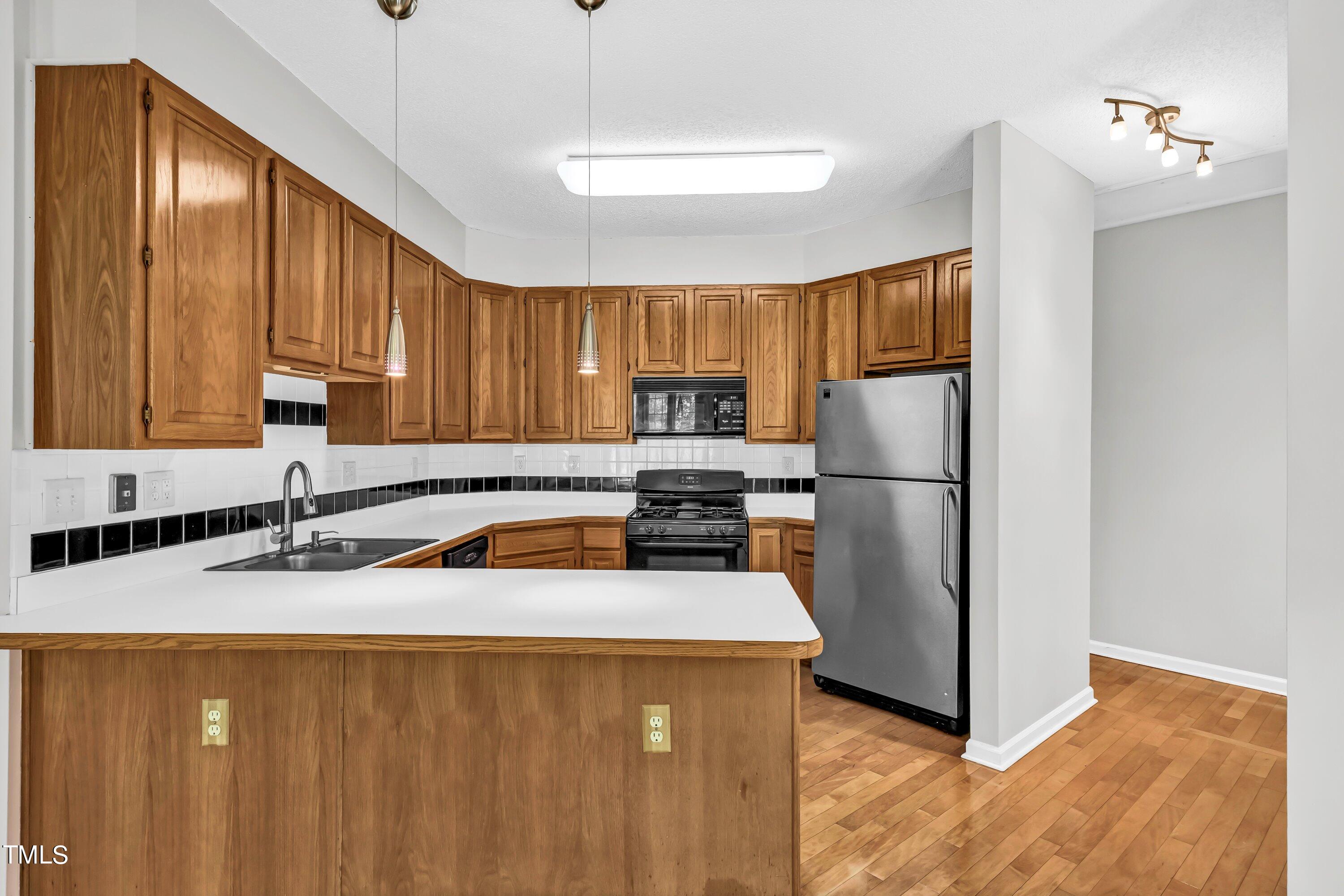 816 Kings Cross Way Raleigh, NC 27615 - Photo 8 of 41 a kitchen with granite countertop wooden cabinets a sink a stove a refrigerator and cabinetry