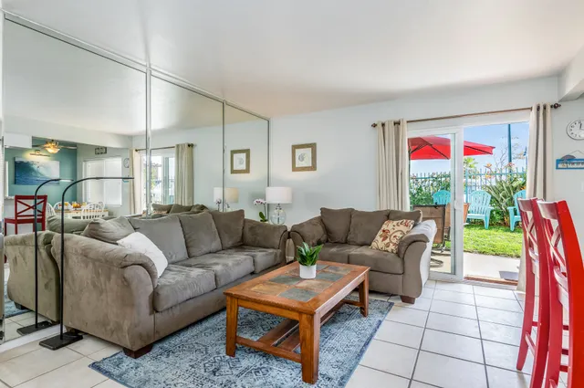 a living room with furniture and a open kitchen view