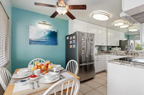 a kitchen with stainless steel appliances kitchen island granite countertop a microwave a stove and a dining table