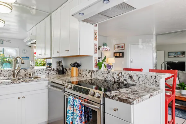 a kitchen with stainless steel appliances granite countertop a sink stove and cabinets