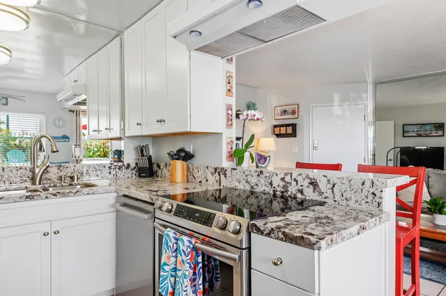 a kitchen with stainless steel appliances granite countertop a sink stove and cabinets