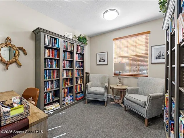 a living room with furniture a bookshelf and a window