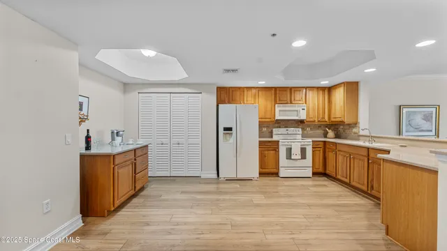 a kitchen with stainless steel appliances granite countertop a refrigerator and a stove top oven