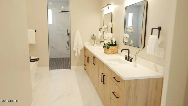 a bathroom with double vanity and mirrors