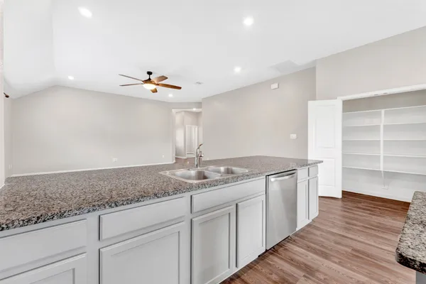 a open hall with kitchen island white cabinets and wooden floor