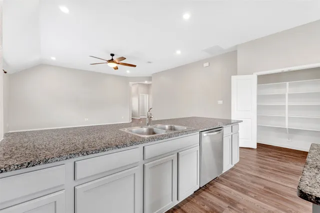 a open hall with kitchen island white cabinets and wooden floor