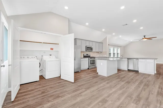 a view of a kitchen with refrigerator and wooden floor