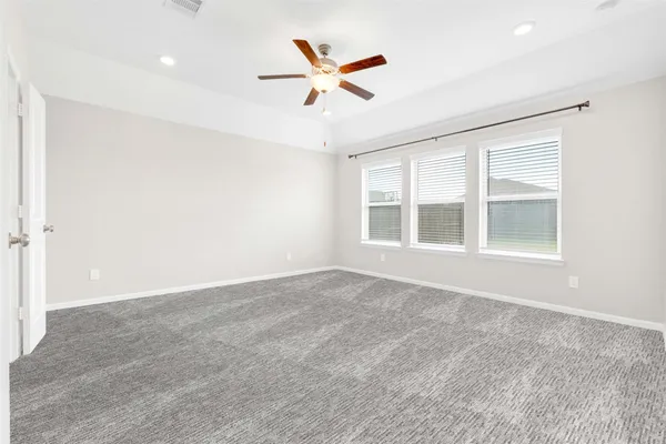 an empty room with ceiling fan and window