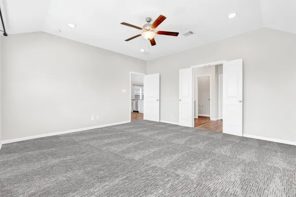 an empty room with closet and ceiling fan