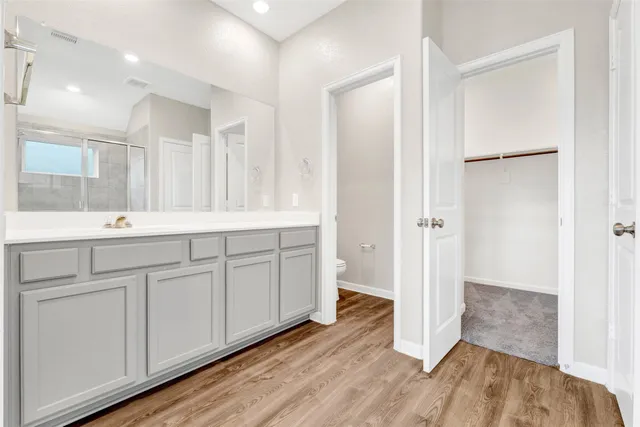 a spacious bathroom with a double vanity sink a mirror and a shower