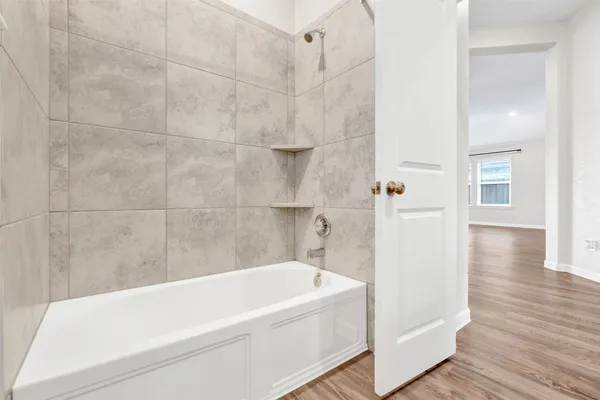 a white bath tub sitting next to a white wall