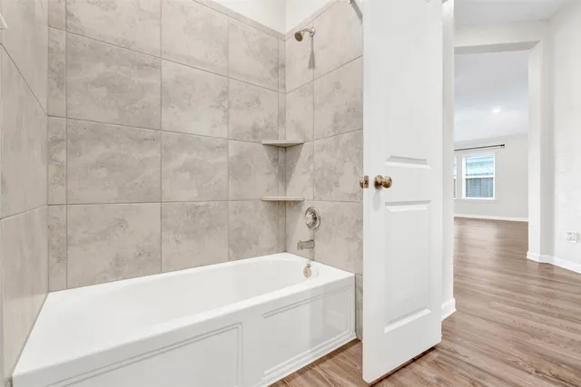 a white bath tub sitting next to a white wall