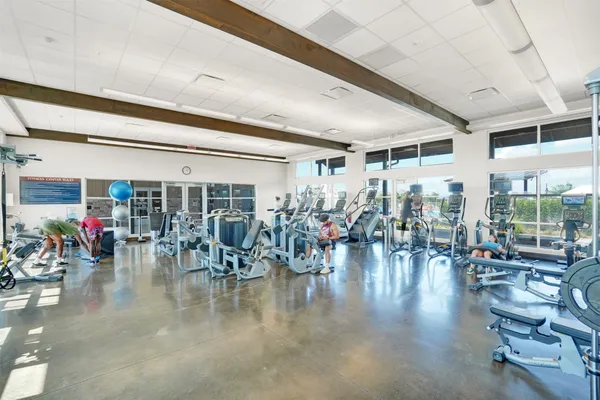 a gym room with lots of furniture and gym equipment