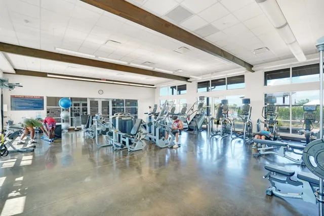 a gym room with lots of furniture and gym equipment